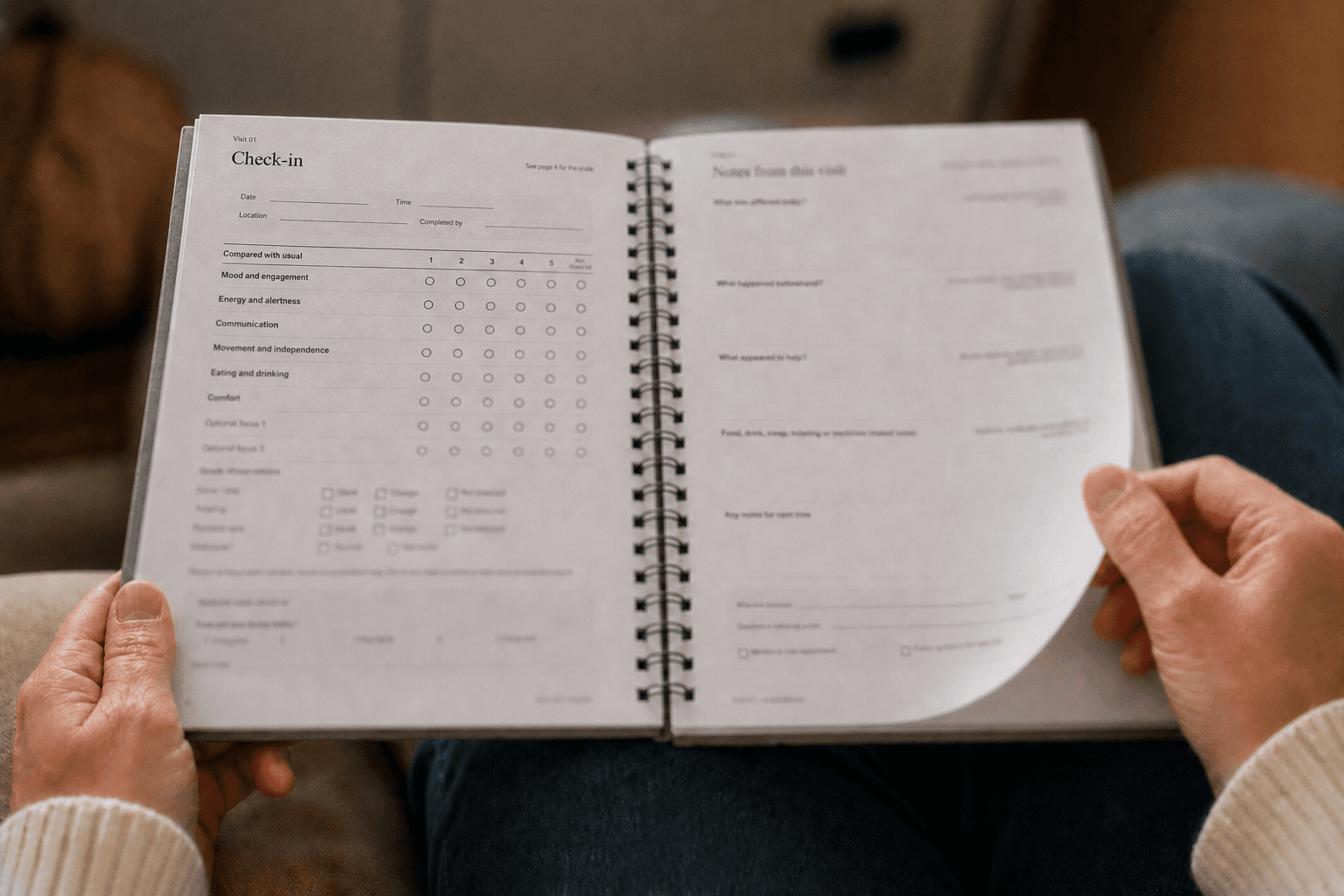 Seen With Care Care Journal open across a person's lap, with the upper-left Check-in heading in focus as the Notes page is turned